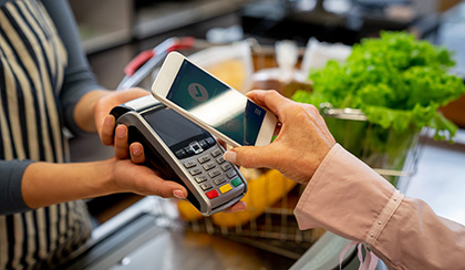 Customer using phone to pay for item.